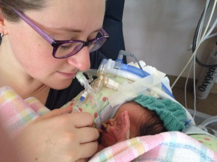 A mom looks at her newborn baby in the hospital. 