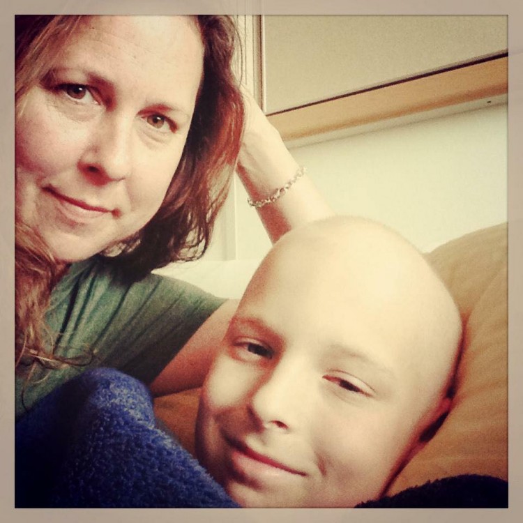A mom and her child, who has no hair. 