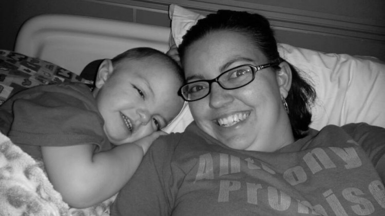 A little boy and his mom laying in a hospital bed. 