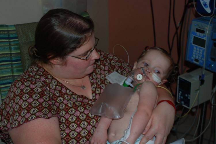 A mom holds a baby in a hospital. 