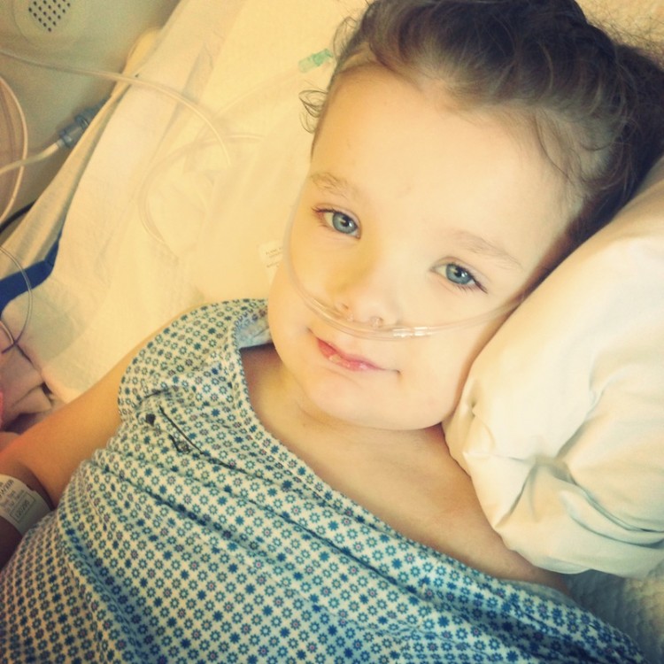 young child in hospital bed with oxygen tube