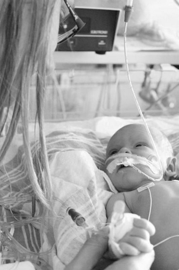 A mom looks down at her baby in the hospital. 