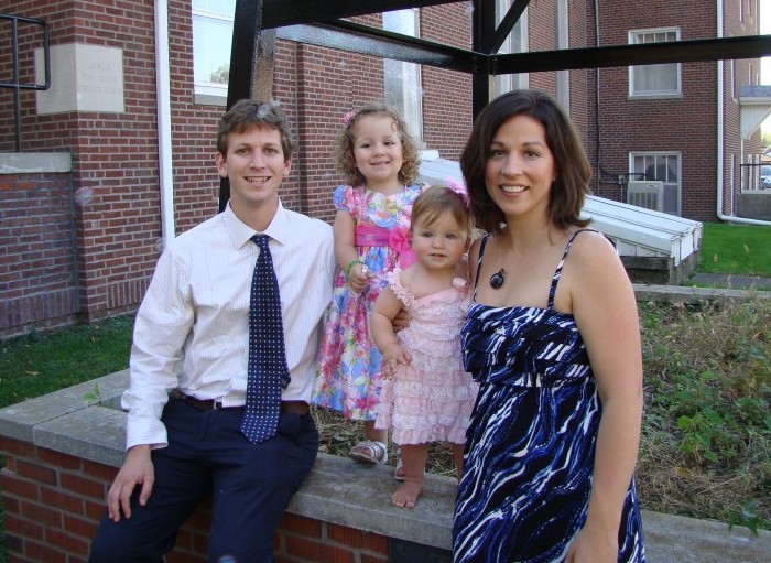 parents standing outside with two little girls