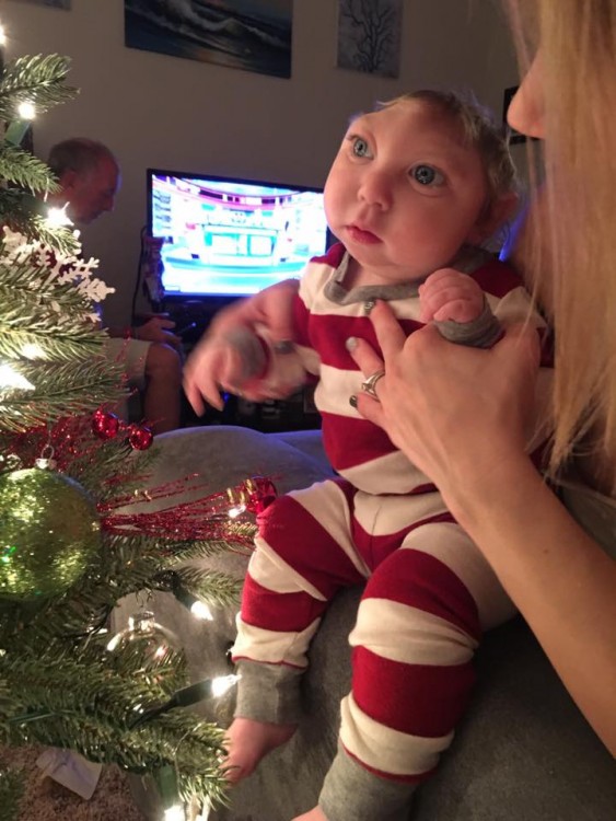 author's son by their christmas tree at home