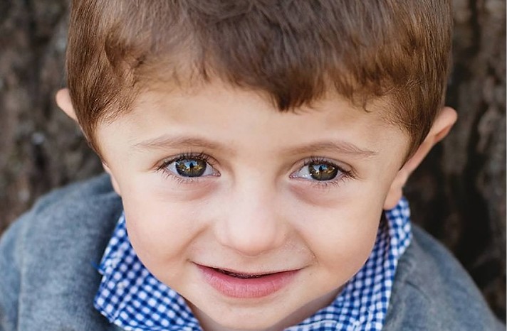young boy with brown hair and blue shirt