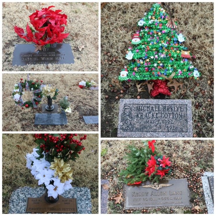 Several different headstones with Christmas flowers and decorations on them.