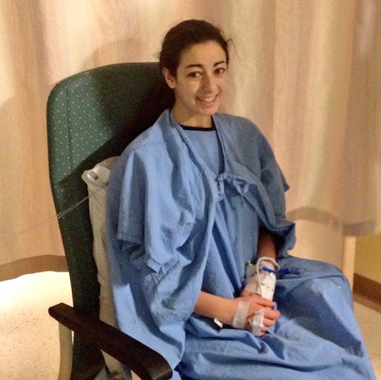 Woman sitting in the hospital wearing a hospital gown