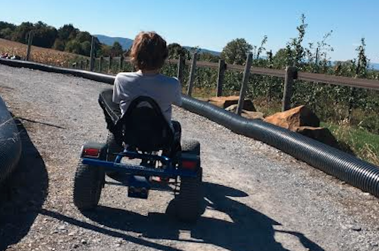 boy riding on wheeled vehicle on track