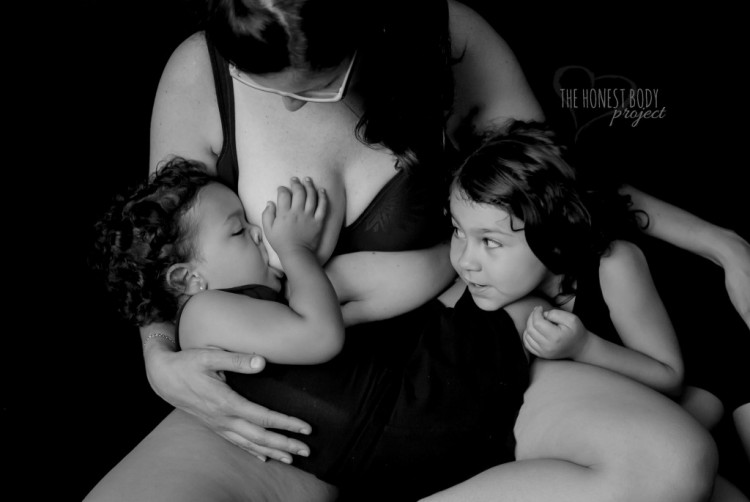 Mom breastfeeding baby and holding kids