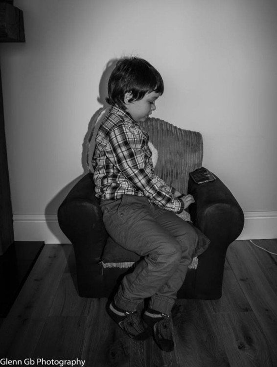 Photo of a young boy in a chair. 