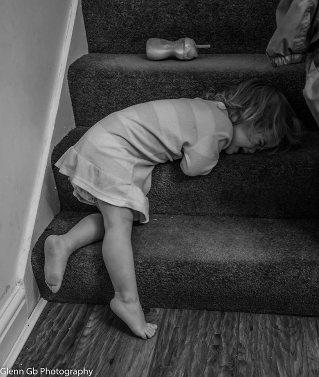A young girl crying on stairs. 