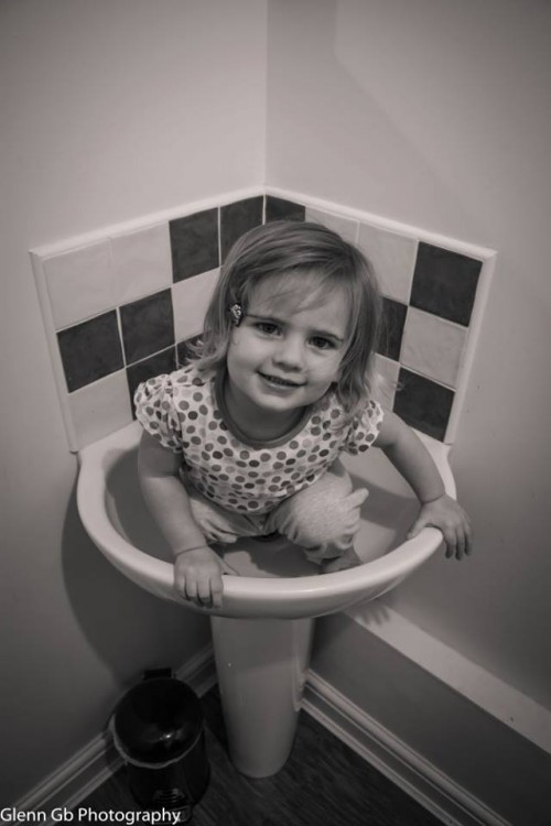 A young girl in a sink. 