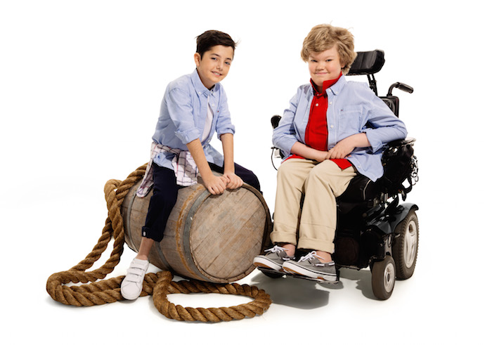 Two children, one in a wheelchair, wearing adaptable clothing.