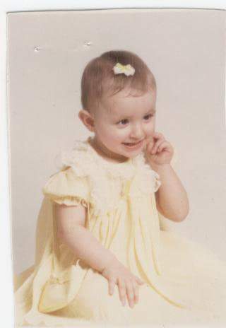 baby girl in a yellow dress with a yellow bow