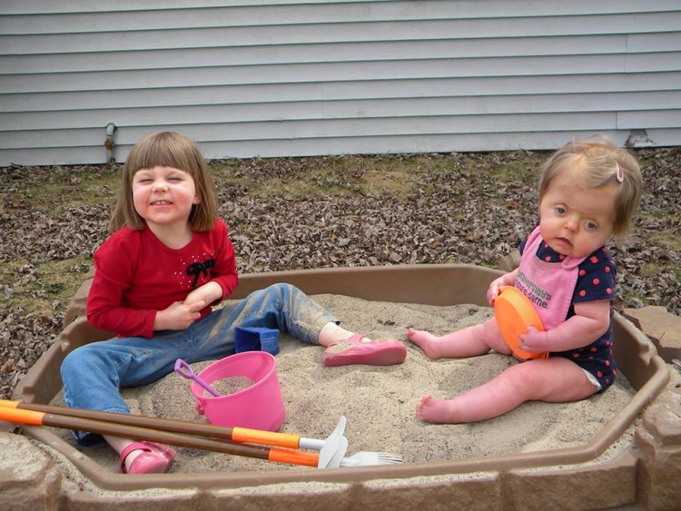 two young girls in sandbox