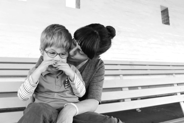 black and white photo of mom kissing her son
