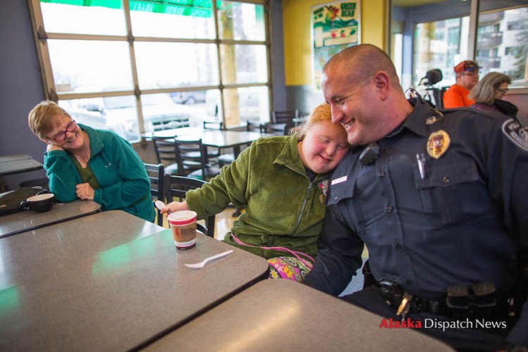 LOREN HOLMES / Alaska Dispatch News Harley Hamilton, a senior at West High living with Down syndrome and autism, gives Anchorage police officer Matt Fraize a side hug at Sagaya City Market on Wednesday, Feb. 24, 2016. Watching at left is DeVon Brentlinger, one of Harley's caregivers.
