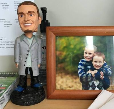 bobblehead of nsync member next to framed photo of two boys