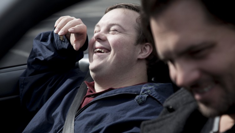 man laughing in passenger seat of car