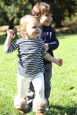 toddler boy and girl running on grass