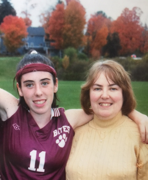 girl wearing sports jersey with arm around mom