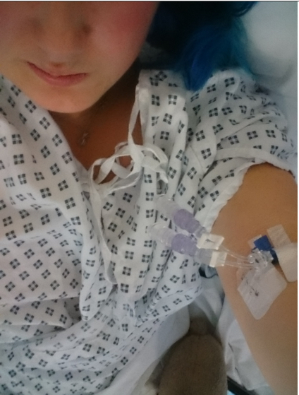 woman in hospital gown showing needle in arm