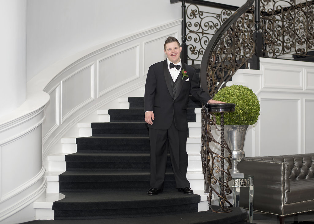 young man in tux on stairs