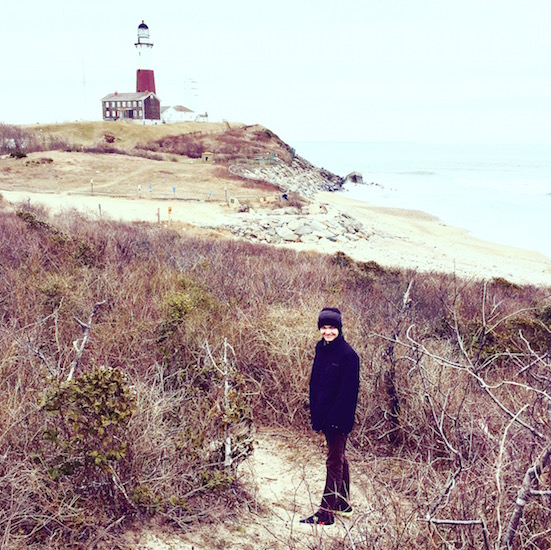 boy standing in front of lighthouse