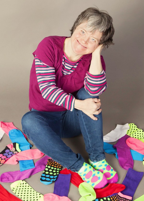 woman sitting and smiling in pile of socks