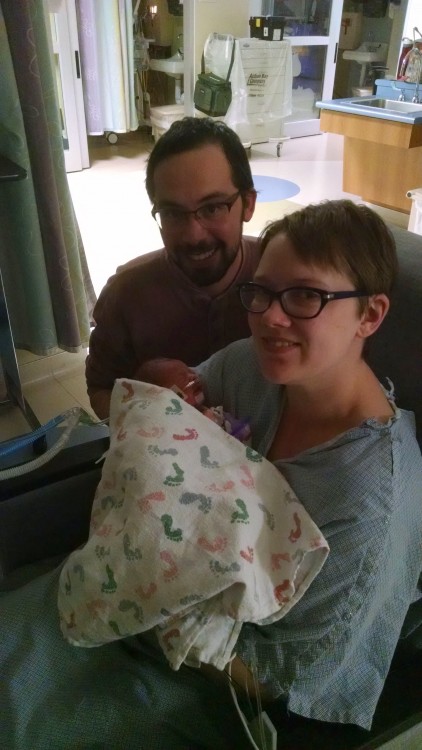 parents holding newborn baby in the hospital