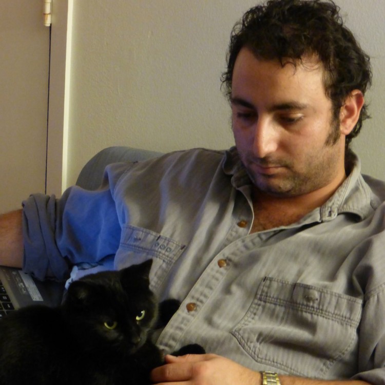 man with black cat on his lap