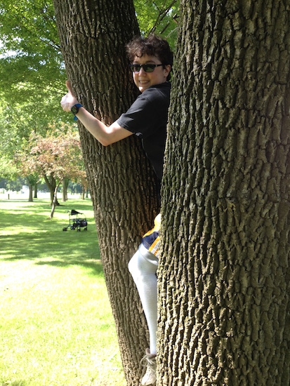 woman climbing tree and smiling