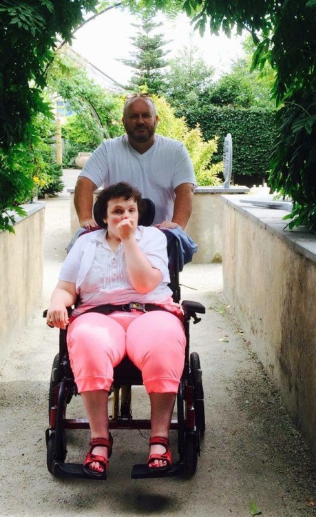 man pushing his adult daughter in wheelchair