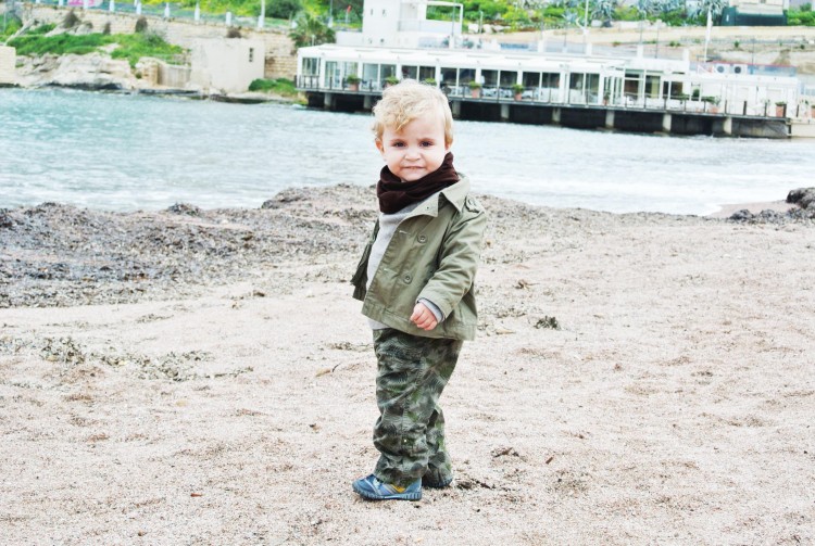 young boy standing on beach