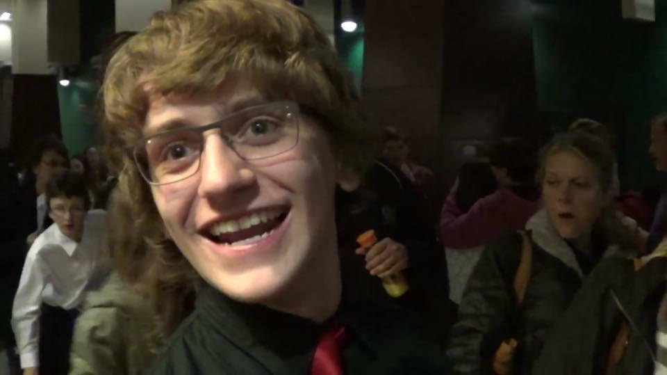 boy with brown hair and glasses smiling at camera