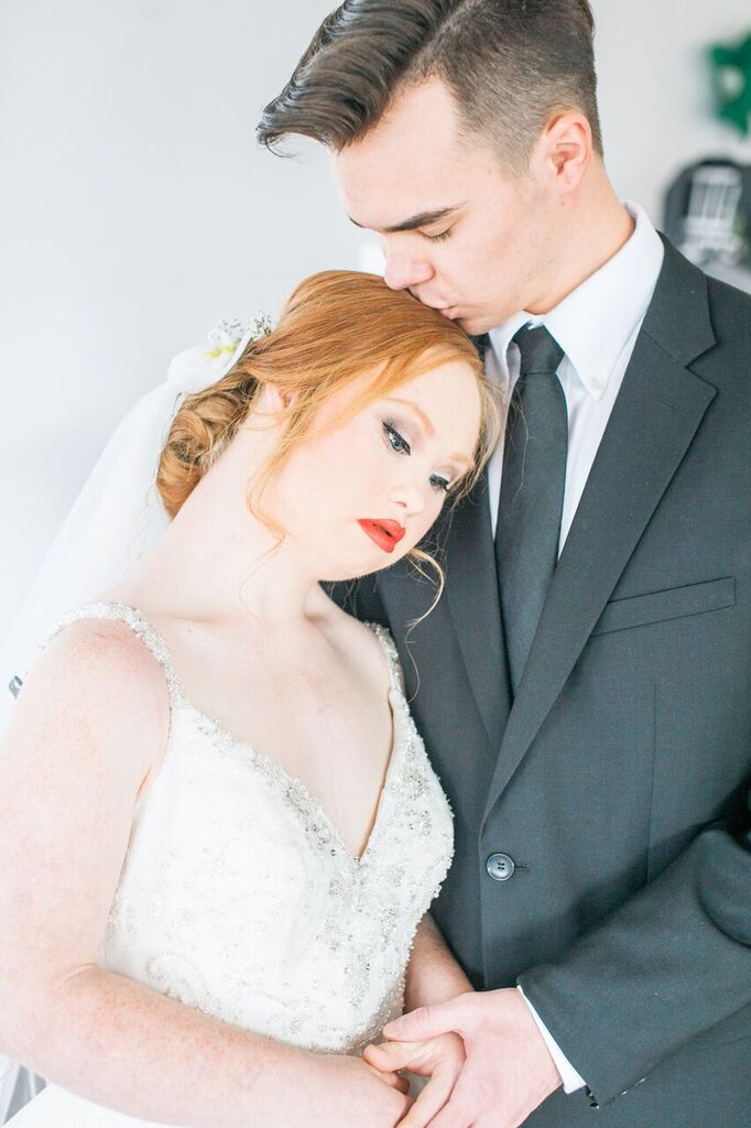 groom kissing madeline stuart on the head