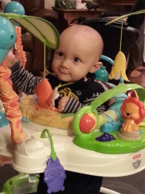 Author's son, Samuel, smiling in play chair