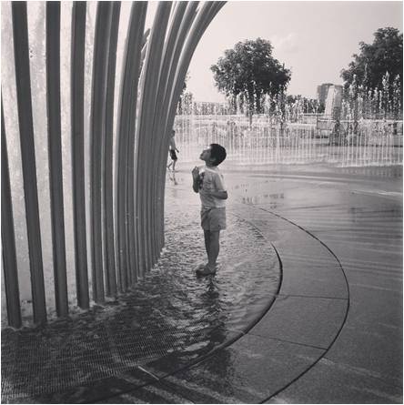 son standing in fountain