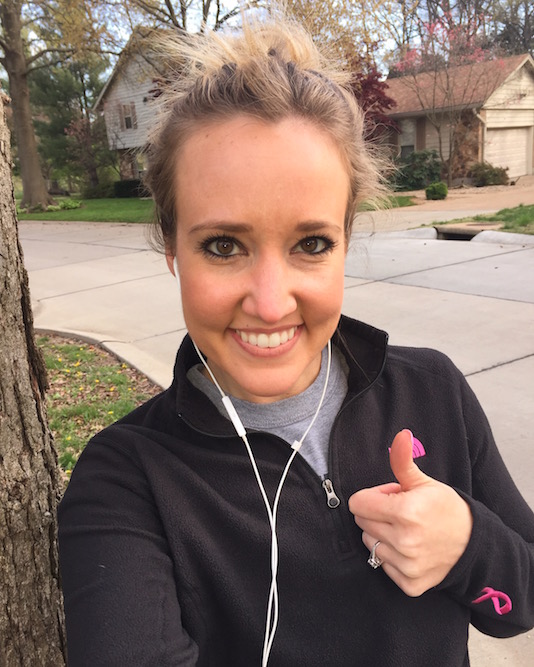 Natalie, ready for a run, wearing headphones and giving the thumbs up