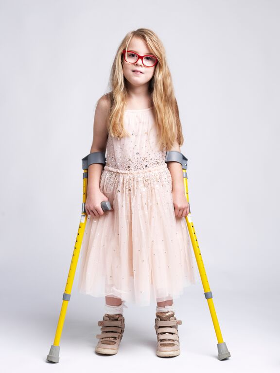 emily in pink dress with crutches