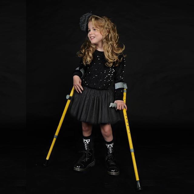 emily in black dress holding crutches