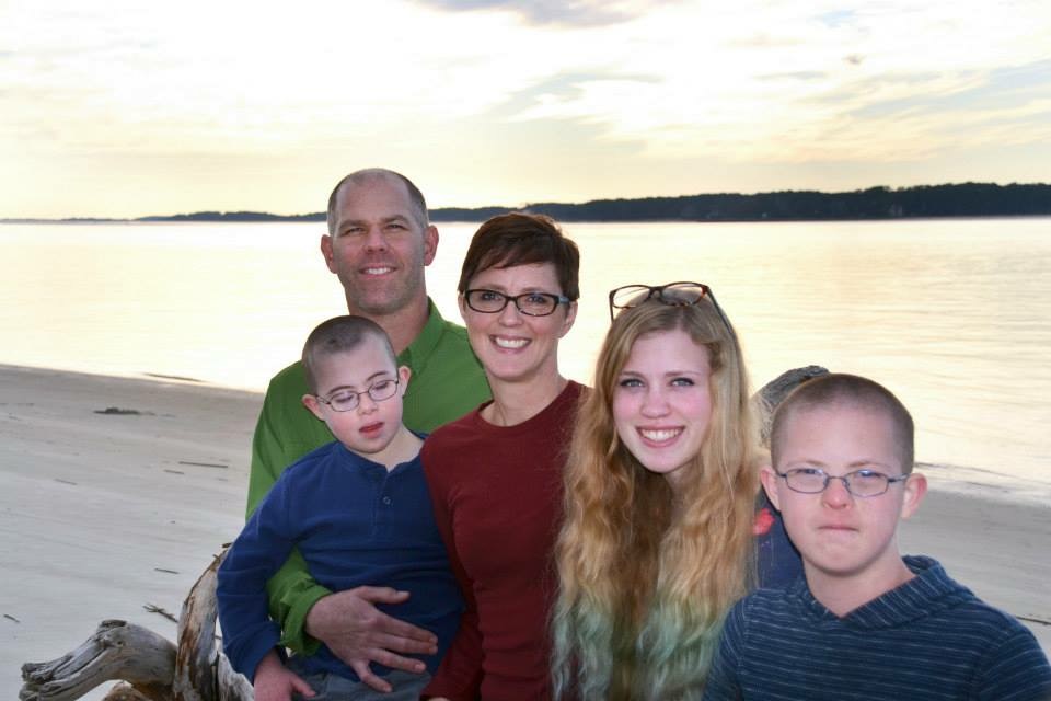 family photo in front of a lake