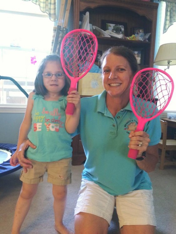 Mother and daughter holding pink rackets.