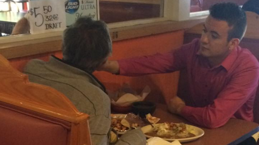A waiter feeds a man with no hands at the Cinco de Mayo Mexican Restaurant in Georgia.