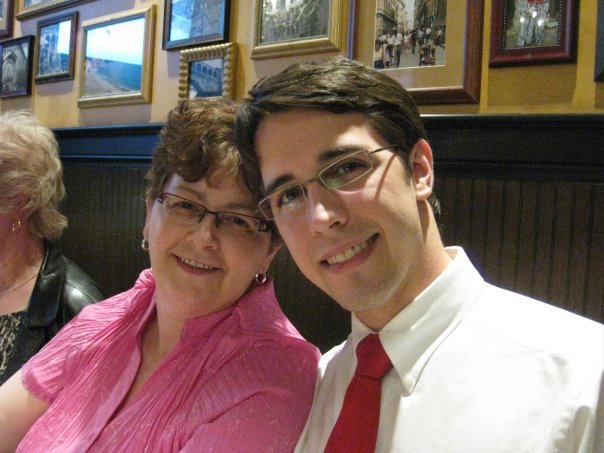 a young man and his mother sitting together and smiling