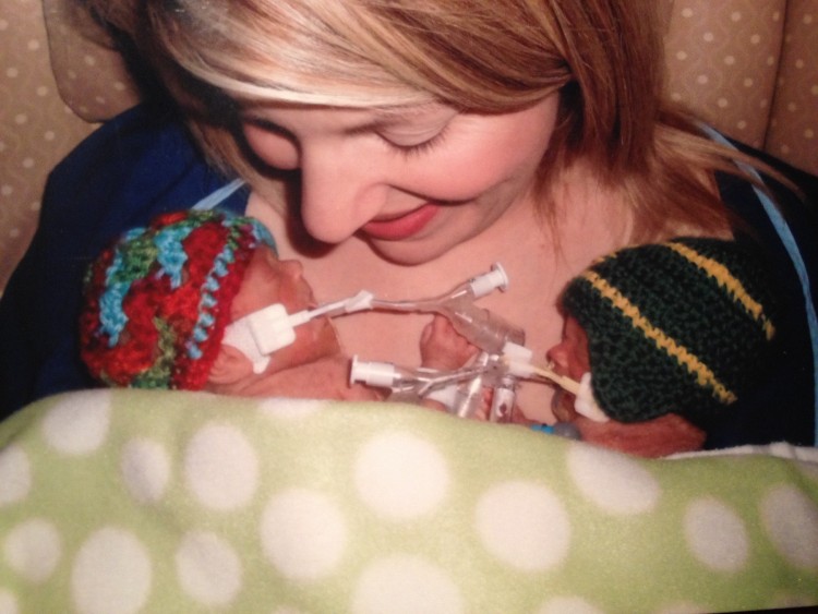 a mother holding two preemies in her arms
