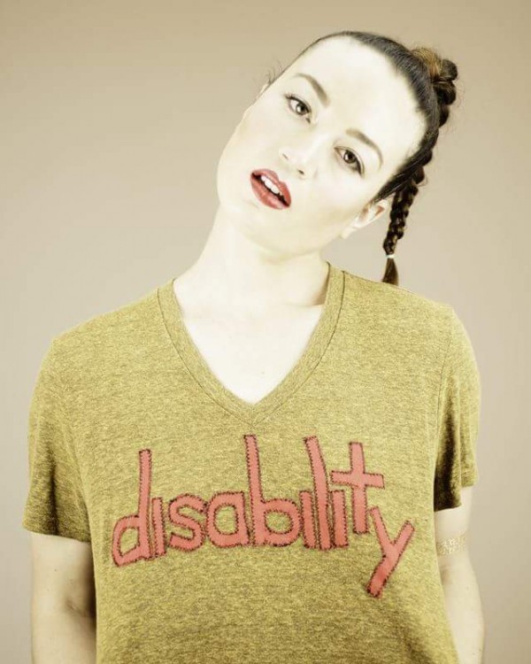 Charis wearing a t-shirt with hand-stitched lettering that says "disability."