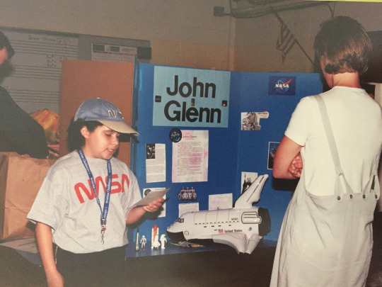 girl giving presentation about john glenn in school