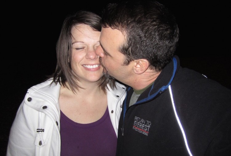 man kissing woman on black background
