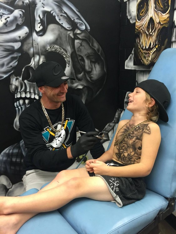 Lloyd tattooing a young boy